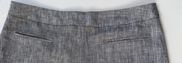 An image of a back view of the grey linen skirt showing pockets