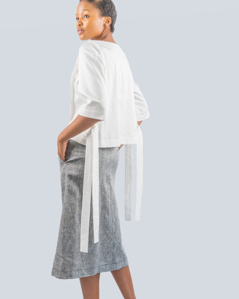 A woman wearing a white top with straps