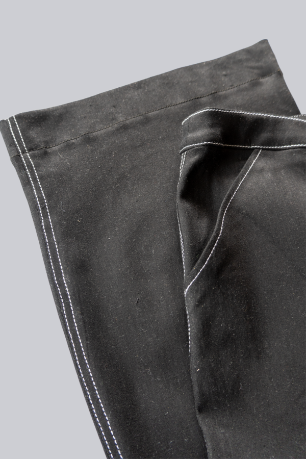 Hem and waistband detail on black pants